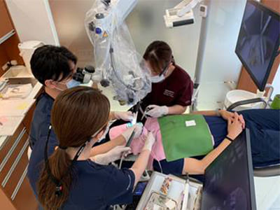 マイクロスコープと衛生士2名による3名体制での精密治療風景